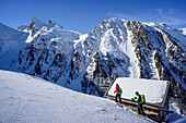 Mann und Frau auf Skitour steigen an Almhütte vorbei zur Frauenwand auf, Frauenwand, Schmirntal, Zillertaler Alpen, Tirol, Österreich