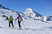 Man and woman back-country skiing ascending towards Schneespitze, Feuerstein in the background, Schneespitze, valley of Pflersch, Stubai Alps, South Tyrol, Italy