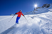 Frau auf Skitour fährt durch Pulverschnee vom Passo Croce ab, Passo Croce, Valle Maira, Cottische Alpen, Piemont, Italien