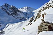 Woman back-country skiing ascending towards Monte Salza, in the background Monte Pence and Buc Faraut, Monte Salza, Valle Varaita, Cottian Alps, Piedmont, Italy