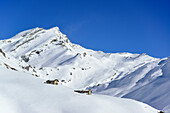 Snow-covered alpine huts in front of Monte Salza, Monte Salza, Valle Varaita, Cottian Alps, Piedmont, Italy