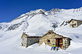 Frau auf Skitour macht an Almhütten Pause, Monte Salza, Valle Varaita, Cottische Alpen, Piemont, Italien