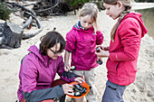 Eine Frau und zwei Mädchen sammeln Miesmuscheln, Südinsel, Neuseeland
