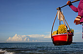 Woman carrying friut, Longbeach on the island of Phu Quoc, Vietnam, Asia