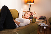 Young woman sitting on the sofa, relaxing