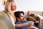 Young couple relaxing on the sofa, Playing on the tablet