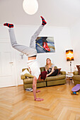 Young man doing a handstand in the lounge