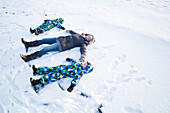 Mutter und Söhne spielen im Schnee, Cuxhaven, Nordsee, Niedersachsen, Deutschland