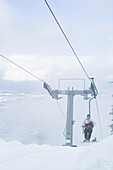 Snowboardfahrer im einser Sessellift, Kampenwand, Alpen, Bayern, Deutschland