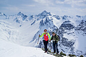 Zwei Personen auf Skitour steigen zum Piz Sursass auf, Piz Ftur und Piz Laschadurella im Hintergrund, Piz Sursass, Sesvennagruppe, Engadin, Graubünden, Schweiz