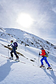 Two persons back-country skiing ascending towards Piz Arpiglia and Piz Uter auf, Piz Arpiglia, Livigno Alps, Engadin, Grisons, Switzerland