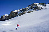 Woman back-country skiing ascending towards Piz Lischana, Piz Lischana, Sesvenna Alps, Engadin, Grisons, Switzerland