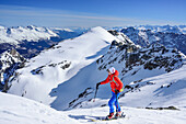 Woman back-country skiing ascending towards Piz Lischana, Piz Lischana, Sesvenna Alps, Engadin, Grisons, Switzerland