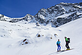 Two persons back-country skiing standing at glacier of Dreiherrnspitze, Dreiherrnspitze, valley of Ahrntal, Hohe Tauern range, South Tyrol, Italy