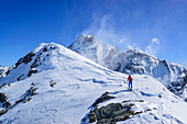 Frau auf Skitour steigt zur Punta Tre Chiosis auf, im Hintergrund Monte Viso, Punta Tre Chiosis, Valle Varaita, Cottische Alpen, Piemont, Italien