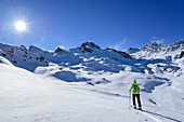 Woman back-country skiing ascending towards Rocca La Marchisa, Rocca La Marchisa, Valle Varaita, Cottian Alps, Piedmont, Italy