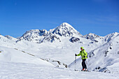 Woman back-country skiing ascending towards Pizzo Tresero, Koenigsspitze in background, Pizzo Tresero, Val dei Forni, Ortler range, Lombardy, Italy
