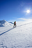 Frau auf Skitour steigt zum Munt Buffalora auf, Piz Daint im Hintergrund, Munt Buffalora, Ofenpass, Sesvennagruppe, Engadin, Graubünden, Schweiz