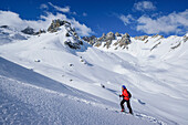 Woman back-country skiing ascending towards Monte Soubeyran, Monte Soubeyran, Valle Maira, Cottian Alps, Piedmont, Italy