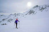 Woman back-country skiing ascending in bad weather towards Colle della Scaletta, Colle della Scaletta, Valle Maira, Cottian Alps, Piedmont, Italy