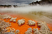 Rain storm approaches Champagne Pool, volcanic lake has constant 74 degree Celsius water including minerals gold, silver mercury, sulphur, and arsenic, Wai-O-Tapu Thermal Wonderland, Rotorua, North Island, New Zealand