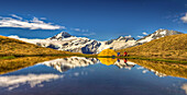 Campers brewing coffee at campsite at Cascade Saddle, Mount Aspiring beyond, Mount Aspiring National Park, New Zealand