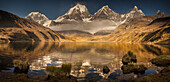 Siula Grande, Yerupaja, Yerupaja Chico and Jirishanca peaks emerge from morning cloud with reflections in Carhuacocha Lake, Cordillera Huayhuash, Andes, Peru