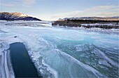 Icy river through the forested mountains of the Yukon, White River, Canada