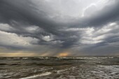 Dark storm clouds and rain over ocean, IJmuiden, Netherlands
