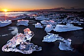 Chunks of ice on coastline near Jokulsarlon at sunset, Iceland