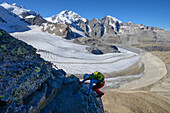 Frau im Klettersteig am Piz Trovat mit Blick auf Bellavista (3922 m), Piz Bernina (4049 m), Piz Morteratsch (3751 m) sowie Pers- und Morteratschgletscher, Engadin, Graubünden, Schweiz