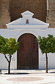 Parroquia de Nuestra Señora de la Granada, Kirchtür und Orangenbäume in Moguer, Provinz Huelva, Andalusien, Spanien
