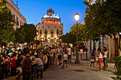 viele Menschen an Tischen und auf der Strasse am Abend in der Calle Larga und Restaurant El Gallo Azur im Hintergrund, Jerez de la Frontera, Provinz Sevilla, Andalusien, Spanien