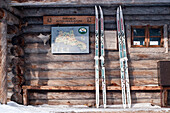 Two pairs of finnish backcountry skis, so called Metsasukset, leaning against the wooden front of the Sarvioja Hut, Urho Kekkonen National Park, finnish Lapland, Finland