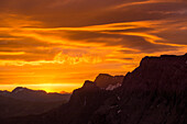 The sun rising between the summits of Seewlehore und Tierberg, just right of the middle the dominant Spitzhorn, Bernese Alps, canton of Bern, Switzerland