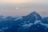 The sun setting next to the summit of the Dent Blanche, Pennine Alps, canton of Valais, Switzerland