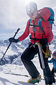Zwei junge Bergsteigerinnen mit Steigeisen, Stock und Pickel steigen die verschneite Südwestflanke des Mont de l‘Etoile hoch, Val d‘Hérens, Walliser Alpen, Kanton Wallis, Schweiz