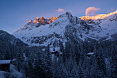 Häuser des Dorfs La Fouly am frühen Morgen, dahinter die Gipfel des Mont Grépillon im ersten Sonnenlicht, Val Ferret, Walliser Alpen, Kanton Wallis, Schweiz