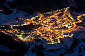 Die Lichter des Dorfs Leukerbad leuchten in der Nacht, Berner Alpen, Kanton Wallis, Schweiz