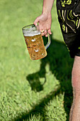 Man wearing traditional clothes holding a glass of beer, Viehscheid, Allgau, Bavaria, Germany