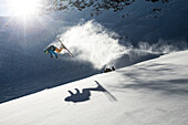 Young male skier doing a backflip over a rock, Pitztal, Tyrol, Austria