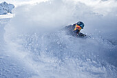 Junge Freeskierin fährt im Tiefschnee in den Bergen, Pitztal, Tirol, Österreich