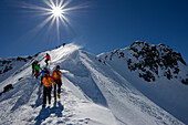 A group of mountaineers descending over the northern ridge of Piz Sarsura (3178 m), Grisons, Switzerland, Europe