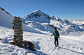 Ski-tourer at the Fuorcla Radoent (2788 m) with view towards Schwarzhorn (3146 m), Grisons, Switzerland, Europe