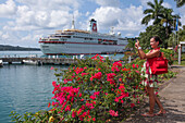 Beautiful woman, flowering bougainvillea and cruise ship MS Deutschland (Reederei Peter Deilmann), Port Antonio, Portland, Jamaica
