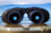 Binoculars aboard cruise ship MS Deutschland (Reederei Peter Deilmann) with mountains in distance, near Lofoten, Norway