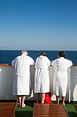 Three elderly passengers wearing white robes aboard cruise ship MS Deutschland (Reederei Peter Deilmann), Mediterranean Sea, near Spain
