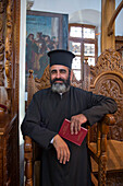 Minister during baptism service inside the Church of the Holy Cross, Omodos, Limassol, Cyprus