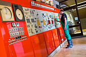 Brewer attends to Steinecker Vollautomatic Sudwerk console at Kitzmann Bräu brewery, Erlangen, Franconia, Bavaria, Germany