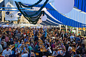 People celebrate in giant beer tent at Bayreuther Volksfest beerfest and amusement park, Bayreuth, Franconia, Bavaria, Germany